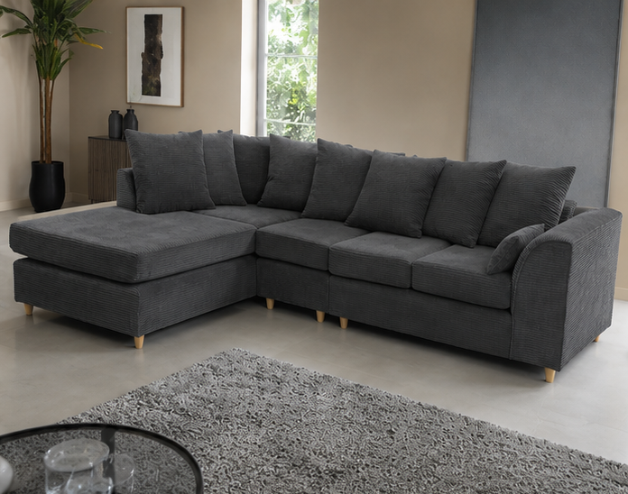 Dark grey jumbo cord corner sofa in a modern living room with minimalist decor and large windows